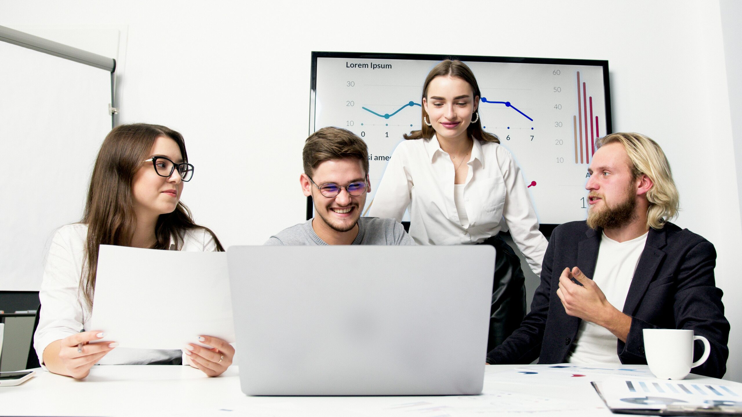 Mehrere junge Menschen schauen auf einen Laptop. Berufseinsteiger