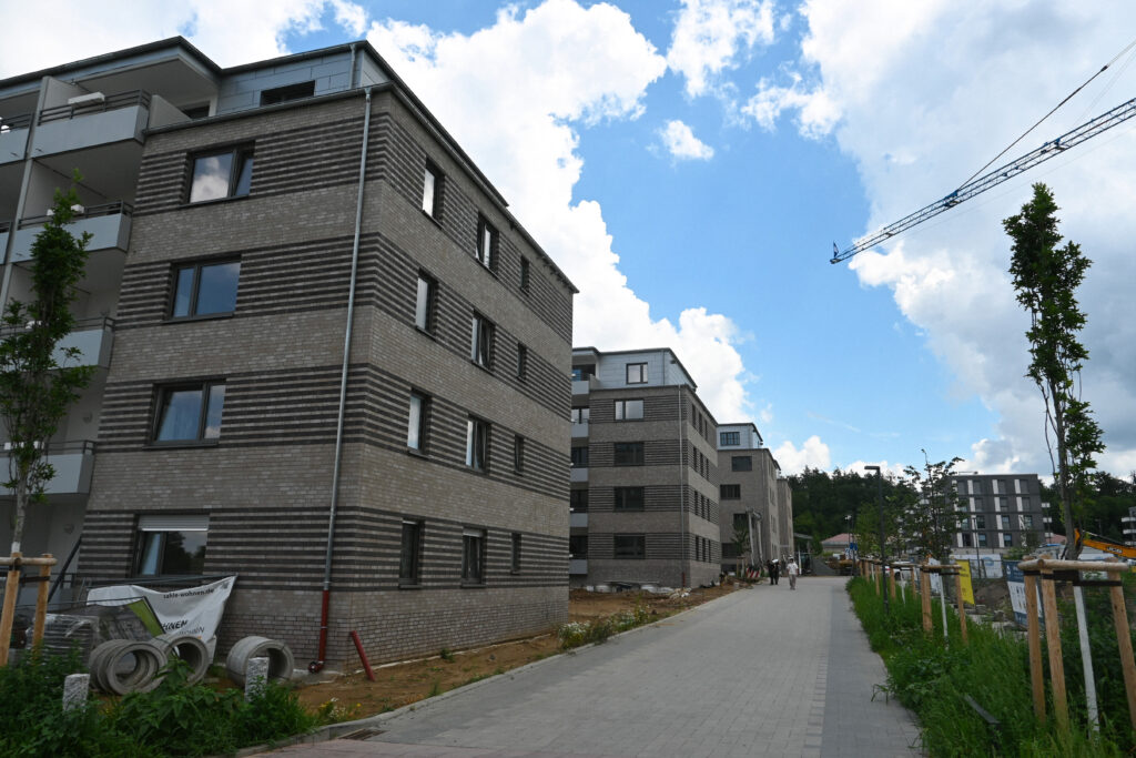 Neubauten im Ludwigshöhviertel in Darmstadt mit mehrstöckigen Wohngebäuden entlang eines Fußwegs, Baukran im Hintergrund
